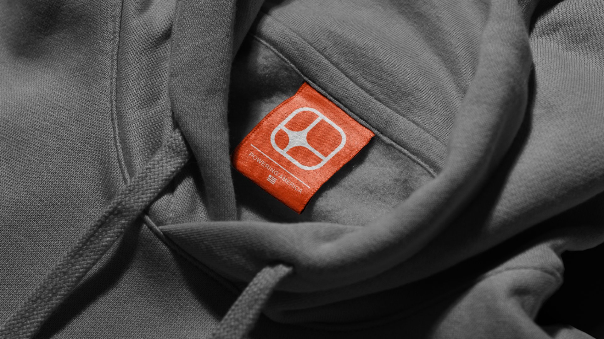 Orange AM Watt brand label on a grey hoodie