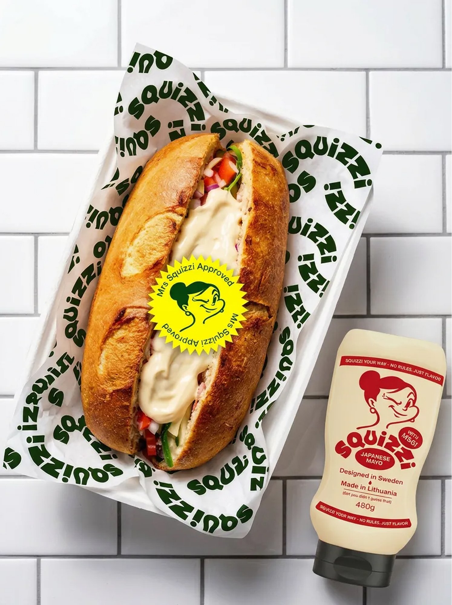 Filled sub roll in Squizzi tray beside a Japanese mayo bottle