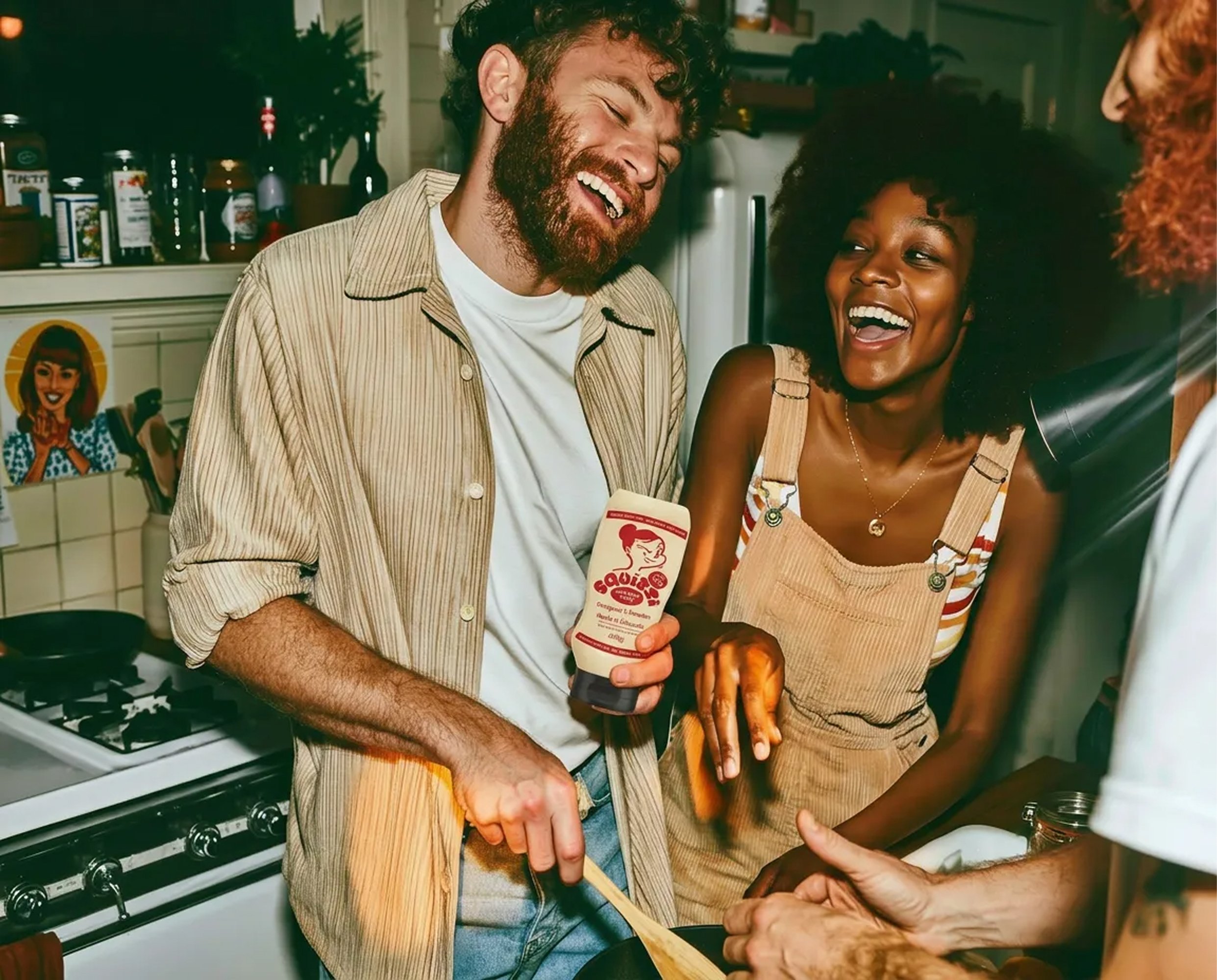Friends laughing in a kitchen while cooking with Squizzi sauce